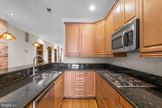 2415 Saint Paul St, Baltimore, MD 21218 - kitchen with appliances with stainless steel finishes, a sink, crown molding, dark stone counters, and light wood-type flooring