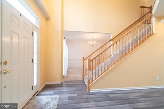 17661 Avenel Ln, Dumfries, VA 22026 - entrance foyer with wood finished floors, stairway, baseboards, a chandelier, and a high ceiling