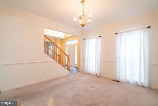 17661 Avenel Ln, Dumfries, VA 22026 - unfurnished living room featuring a chandelier, stairway, and baseboards