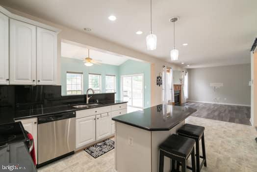 17661 Avenel Ln, Dumfries, VA 22026 - kitchen featuring dishwasher, a sink, open floor plan, dark countertops, and recessed lighting