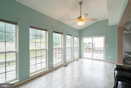 17661 Avenel Ln, Dumfries, VA 22026 - unfurnished living room with healthy amount of natural light, ceiling fan, vaulted ceiling, and baseboards