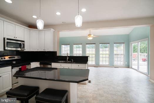 17661 Avenel Ln, Dumfries, VA 22026 - kitchen featuring stainless steel appliances, a kitchen island, decorative backsplash, white cabinets, and recessed lighting