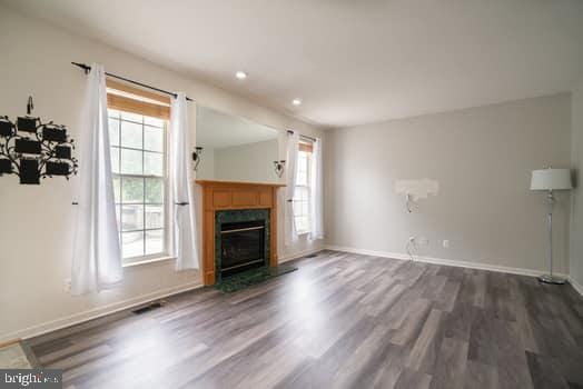 17661 Avenel Ln, Dumfries, VA 22026 - unfurnished living room with dark wood-style flooring, recessed lighting, a glass covered fireplace, and baseboards