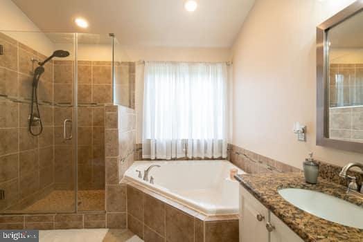 17661 Avenel Ln, Dumfries, VA 22026 - full bathroom with vanity, a shower stall, a garden tub, and recessed lighting