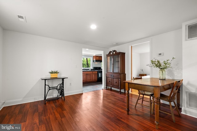 dining space with dark wood-type flooring and baseboards
