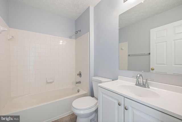 bathroom with toilet, vanity, shower / washtub combination, and a textured ceiling