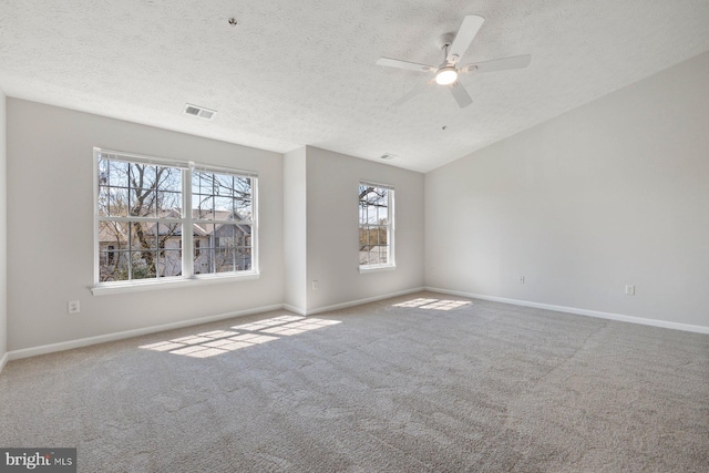 carpeted spare room with baseboards, visible vents, and a ceiling fan