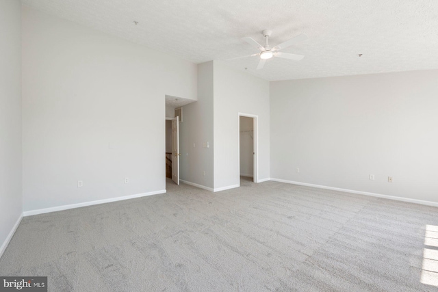spare room featuring high vaulted ceiling, baseboards, a textured ceiling, carpet floors, and a ceiling fan