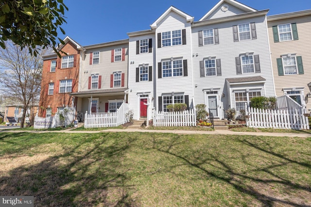 townhome / multi-family property featuring a front lawn