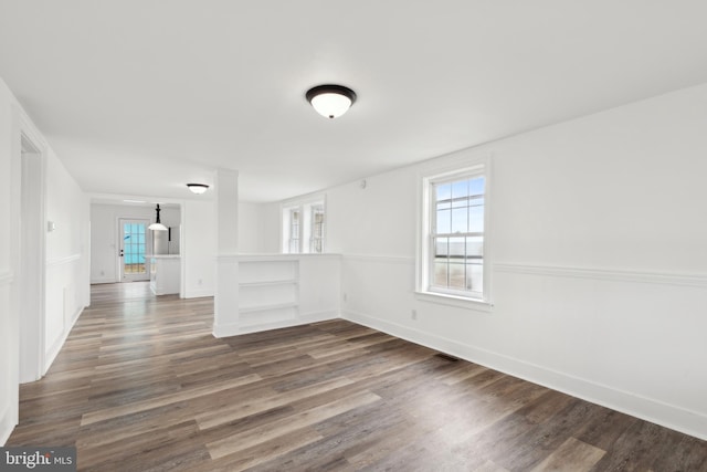 unfurnished room featuring dark wood-style floors and baseboards