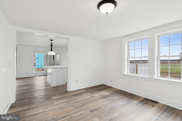 interior space with baseboards, visible vents, and wood finished floors