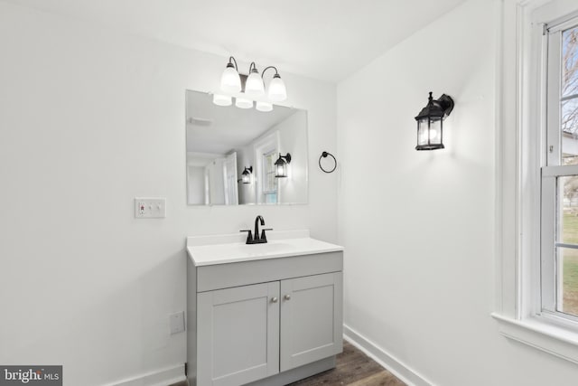 bathroom featuring baseboards, wood finished floors, and vanity