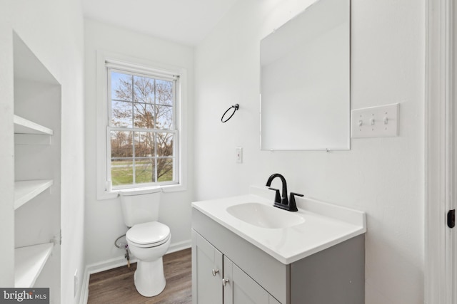 bathroom featuring baseboards, toilet, vanity, and wood finished floors