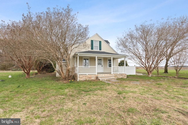 view of front of property featuring a front yard, a porch, and roof with shingles