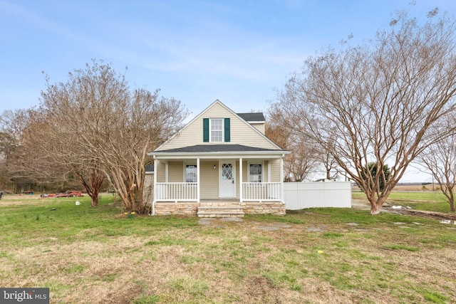 bungalow featuring covered porch, a shingled roof, and a front yard