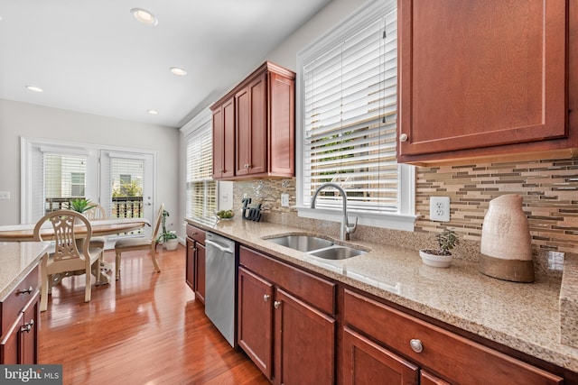 42694 Chisholm, Broadlands, VA 20148 - kitchen featuring stainless steel dishwasher, a sink, light wood-style flooring, decorative backsplash, and light stone countertops