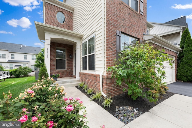 42694 Chisholm, Broadlands, VA 20148 - property entrance with brick siding, driveway, and a garage