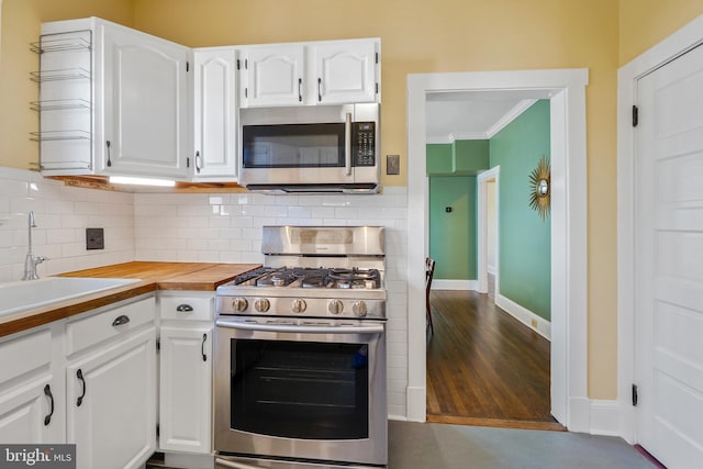 kitchen with white cabinetry, appliances with stainless steel finishes, and decorative backsplash