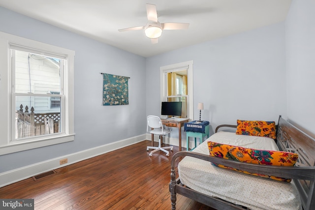 bedroom featuring ceiling fan, visible vents, baseboards, and hardwood / wood-style floors