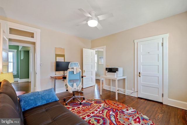 living room featuring a ceiling fan, baseboards, and wood finished floors