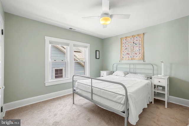 bedroom with visible vents, baseboards, ceiling fan, and light carpet