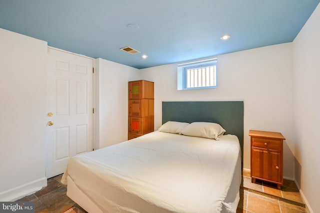 bedroom with baseboards, recessed lighting, stone finish flooring, and visible vents