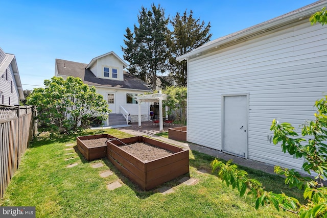 back of house with fence, a wooden deck, a garden, and a lawn