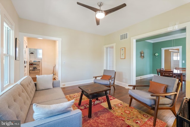 living area with baseboards, ceiling fan, dark wood finished floors, and visible vents