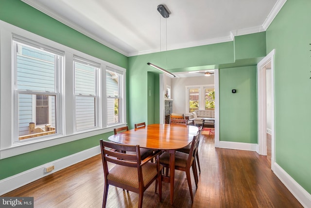 dining area with baseboards, ornamental molding, and wood finished floors