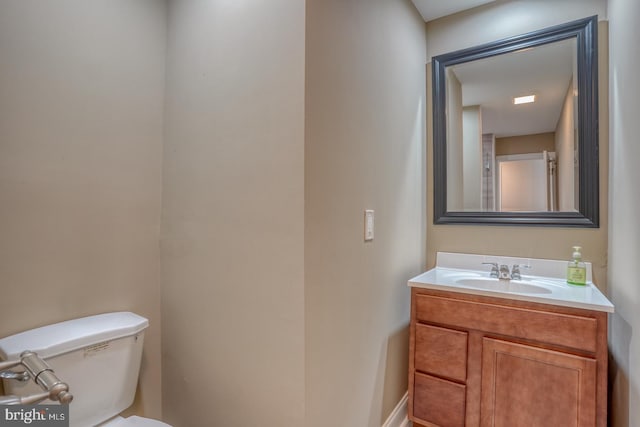 half bathroom featuring vanity and toilet