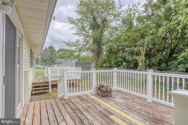 wooden deck featuring a fenced backyard and view of wooded area