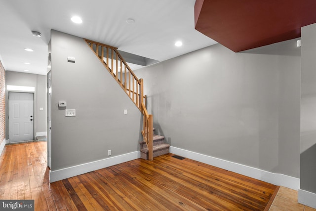 staircase with visible vents, hardwood / wood-style flooring, baseboards, and recessed lighting