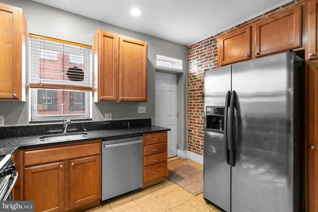 kitchen with a healthy amount of sunlight, light tile patterned floors, a sink, and stainless steel appliances
