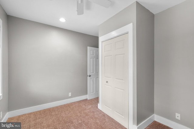 unfurnished bedroom featuring a closet, baseboards, light carpet, recessed lighting, and ceiling fan