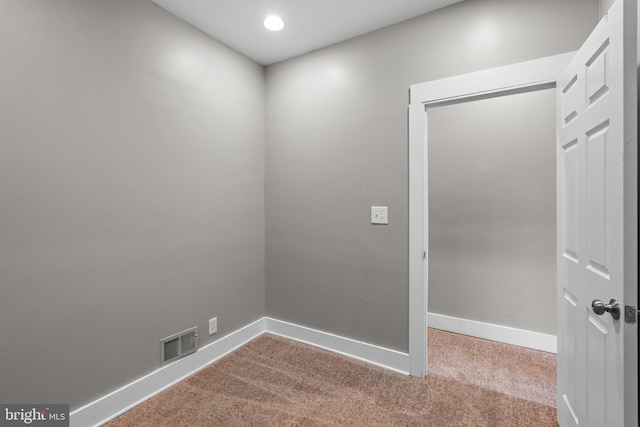 carpeted empty room featuring baseboards and visible vents