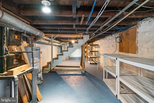 unfinished basement featuring gas water heater and stairs