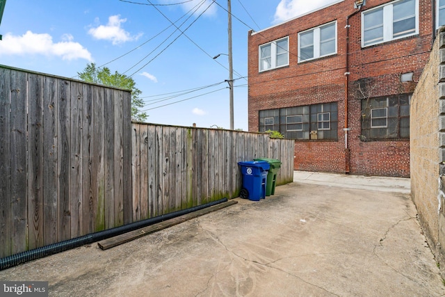 view of side of property with fence and a patio