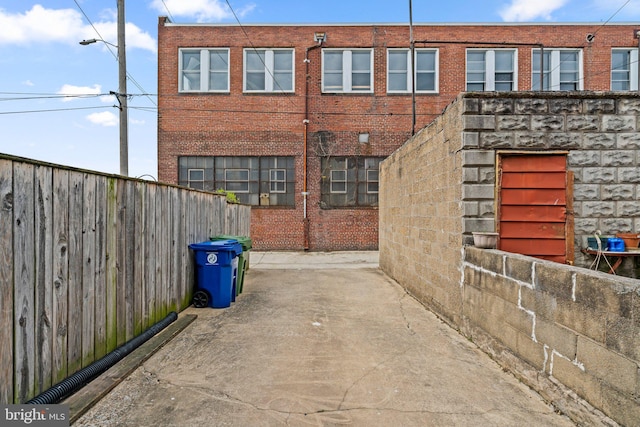 view of property exterior featuring brick siding and fence