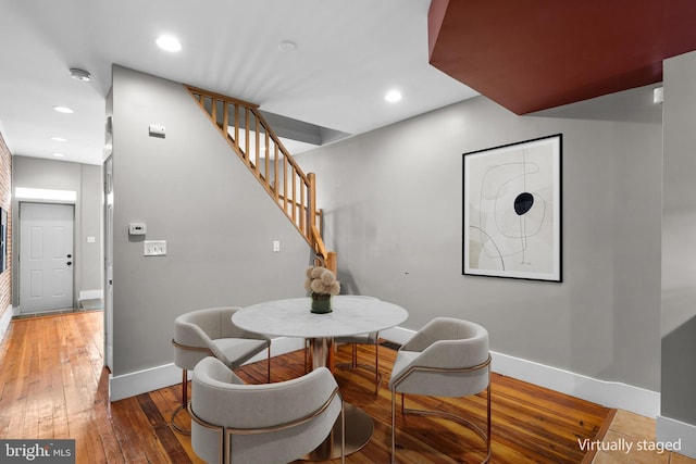 dining room with wood-type flooring, stairway, baseboards, and recessed lighting