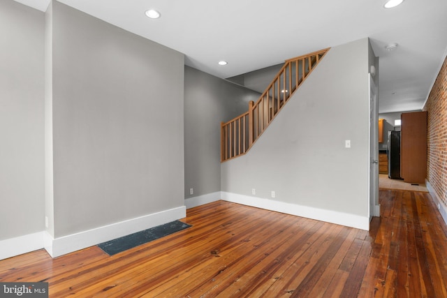 unfurnished room with baseboards, recessed lighting, stairs, and wood-type flooring