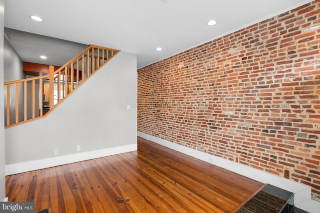 empty room featuring stairway, baseboards, recessed lighting, and hardwood / wood-style flooring