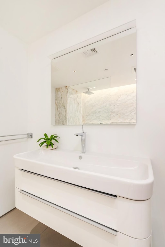 bathroom featuring visible vents, vanity, and walk in shower