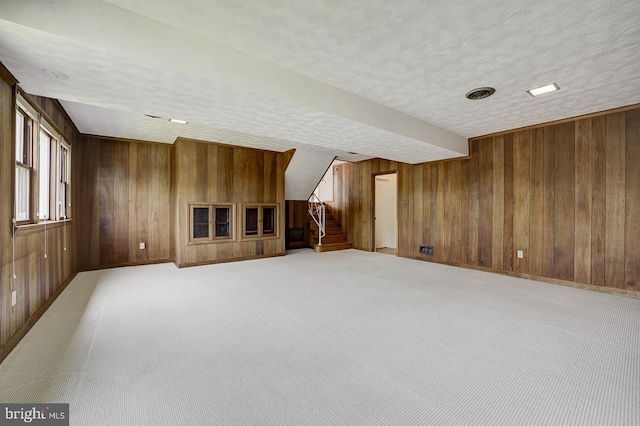 3217 Pauline Dr, Chevy Chase, MD 20815 - unfurnished living room featuring wood walls, stairway, and light colored carpet