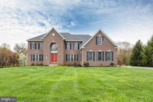 view of front facade with brick siding and a front yard