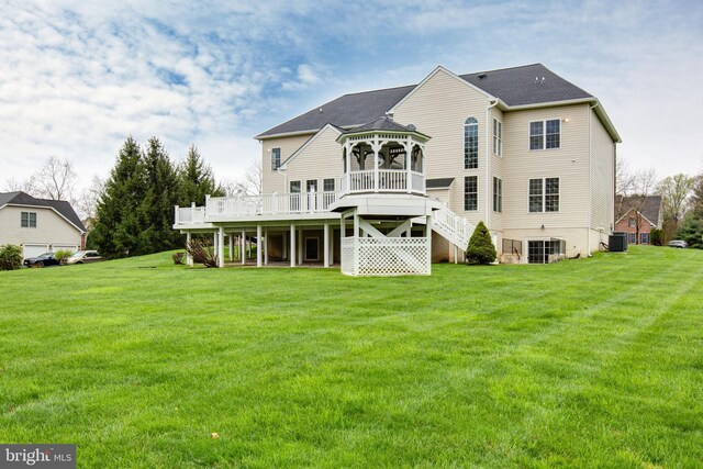 back of property featuring a gazebo, a yard, a wooden deck, and stairs