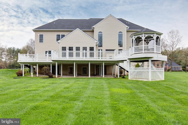 rear view of house with a gazebo, stairway, a yard, and a deck