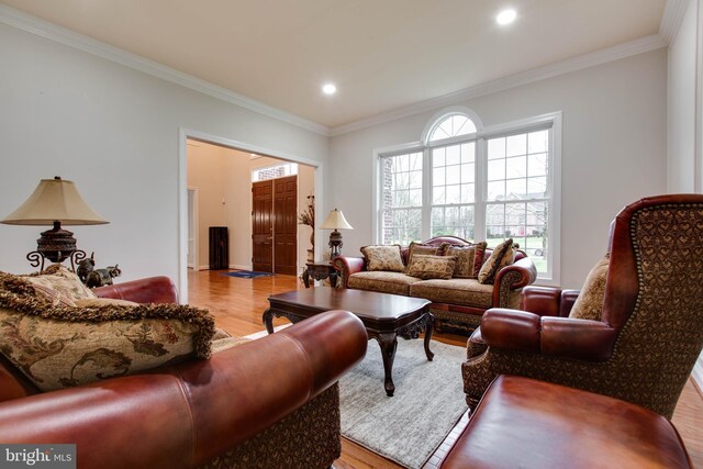 living area with recessed lighting, ornamental molding, and wood finished floors