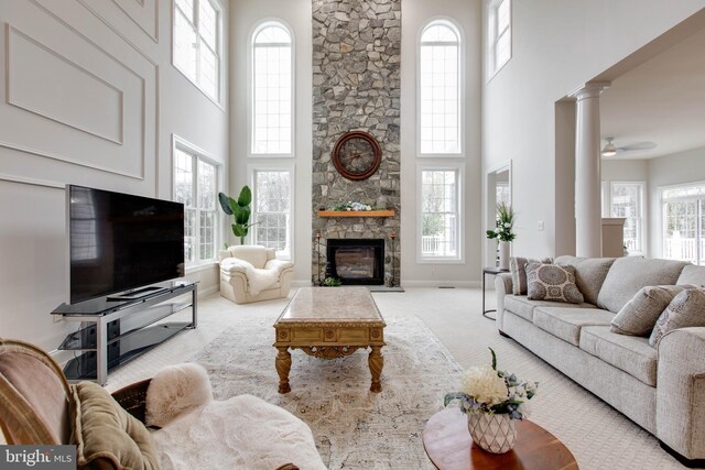 living room with carpet floors, a high ceiling, plenty of natural light, and a fireplace