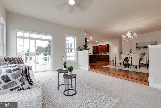 living area featuring baseboards, carpet flooring, ceiling fan with notable chandelier, and recessed lighting