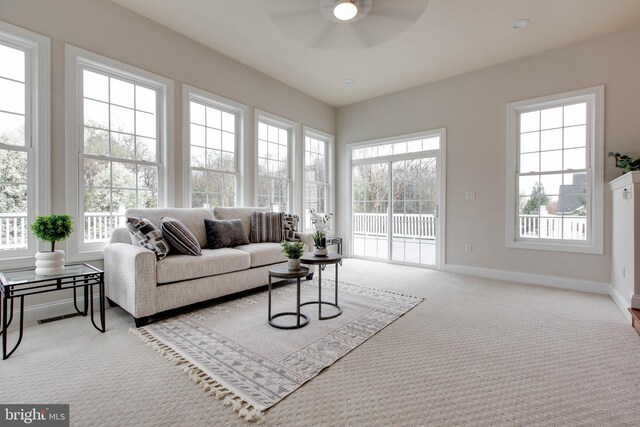 living room featuring a healthy amount of sunlight, ceiling fan, and carpet